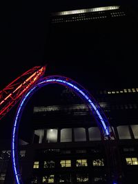 Low angle view of illuminated bridge against sky at night