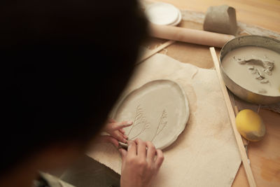 High angle view of woman working on clay