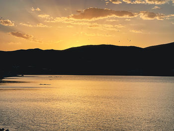 Scenic view of silhouette mountains against romantic sky at sunset