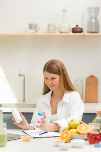 Portrait of young woman sitting at home