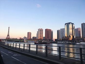 River by city buildings against clear sky