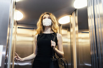 Full length portrait of woman standing in corridor