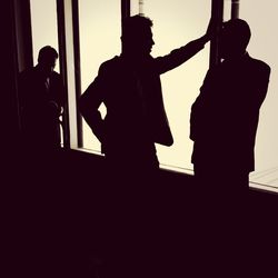 Silhouette people standing against white background