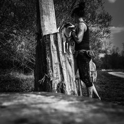 Full length of man standing on tree trunk in forest