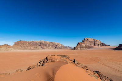 Scenic view of desert against clear blue sky