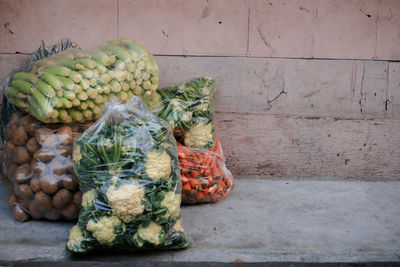 Vegetables in container against wall