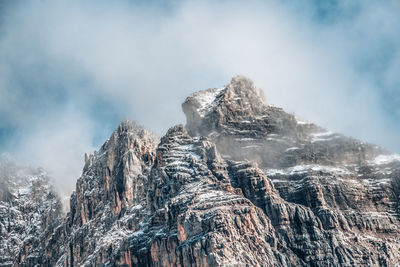 Low angle view of snowcapped mountains against sky
