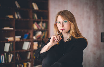 Portrait of young woman holding paintbrush