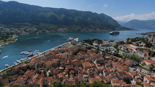 High angle view of townscape by sea against mountain