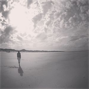 Rear view of woman walking on beach