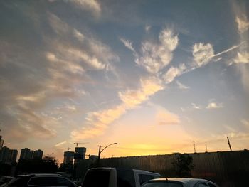 Cars on city against sky during sunset