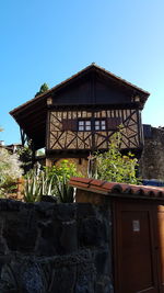 Low angle view of house against clear blue sky