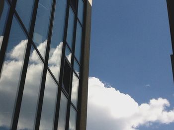 Low angle view of modern building against cloudy sky