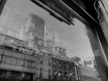 Low angle view of buildings seen through glass window