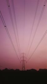 Low angle view of electricity pylon against dramatic sky