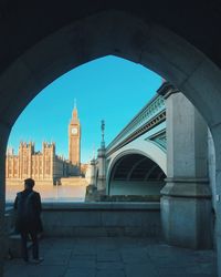 Rear view of people on bridge against clear sky