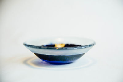 Close-up of tea cup on table against white background