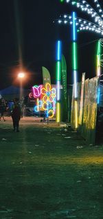 People on illuminated street at night