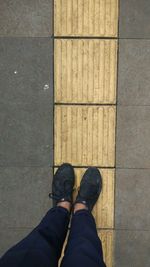 Low section of man standing on tiled floor