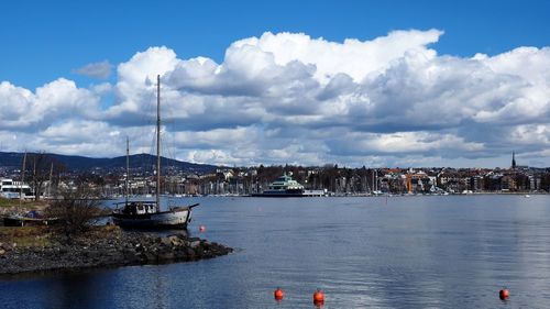 Sailboats in sea against sky in city