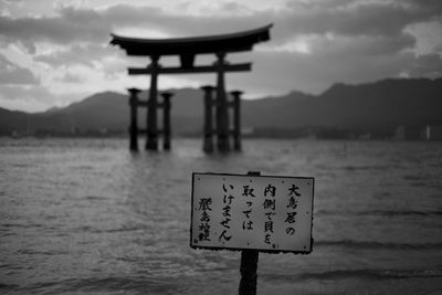 Information sign on sea against sky