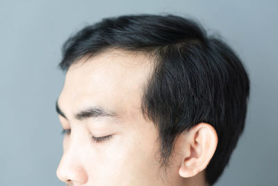 Close-up portrait of young man against white background