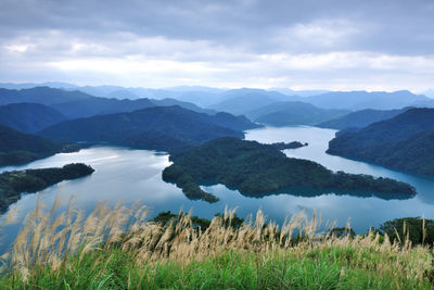 Scenic view of sea and mountains against sky