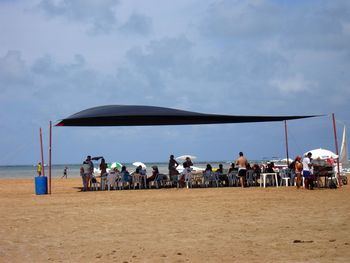 People on beach against sky