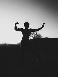 Silhouette man standing on field against clear sky