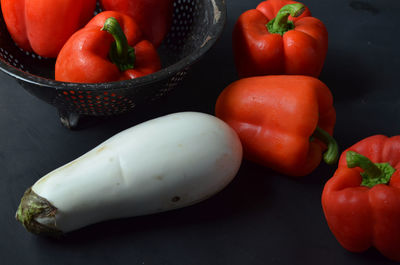 High angle view of red bell peppers and eggplant on table