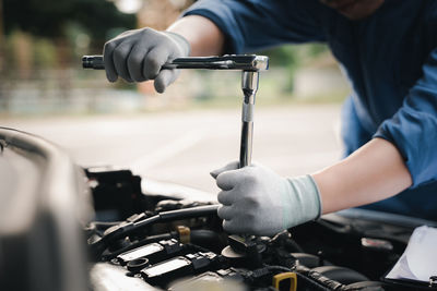 Midsection of man repairing car