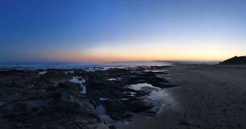 Scenic view of sea against clear sky at sunset