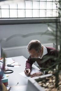 Mature man writing at desk