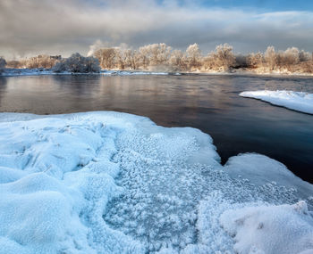 Frozen lake against sky during winter