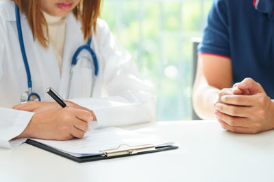 Midsection of woman making face on table