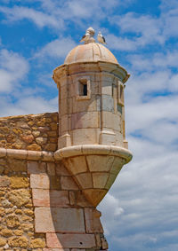 Low angle view of old fortress against cloudy sky