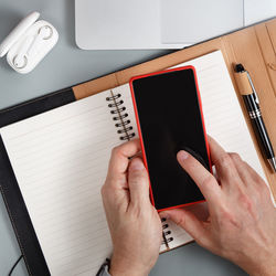 High angle view of man using mobile phone on table