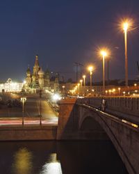 Illuminated bridge over river at night