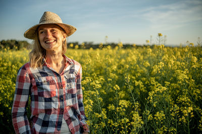 Portraid of a girl smiling in a rapeseed field at sunset