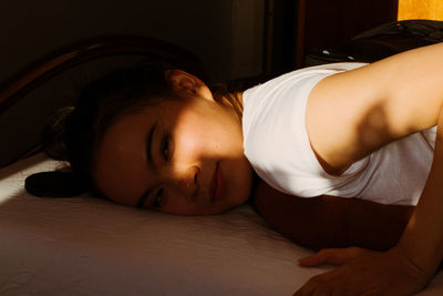 Portrait of woman sleeping on bed at home