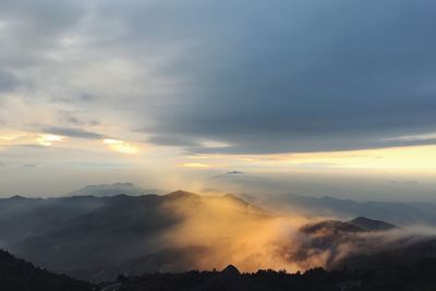 Scenic view of mountains against cloudy sky