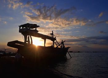 Silhouette boat in sea against sky during sunset