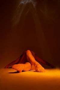 Midsection of man lying down against gray background