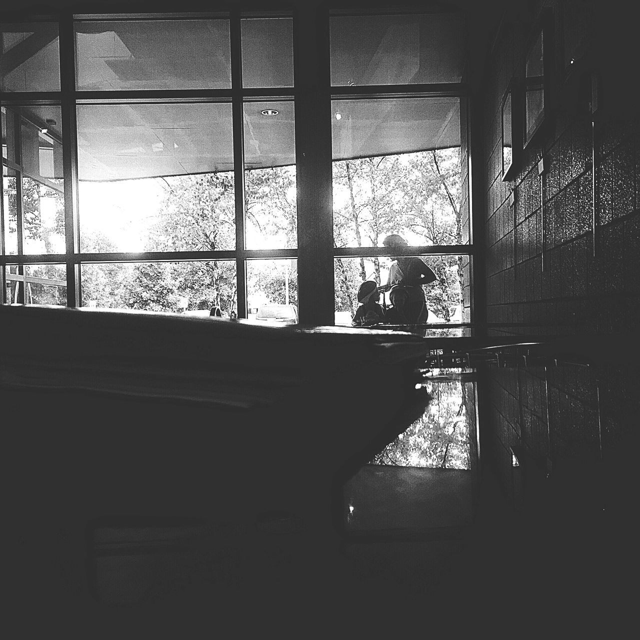 SILHOUETTE OF PEOPLE SITTING ON WINDOW SILL