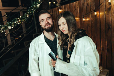 Portrait of young couple standing at night