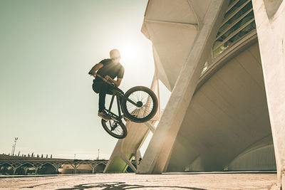 Man performing stunt on bicycle in city 