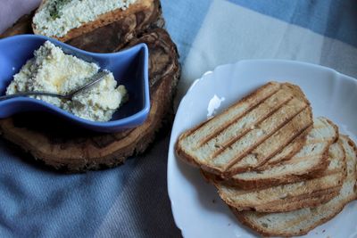 Sandwiches from a loaf and with cheese paste on a wooden stand and in a white plate