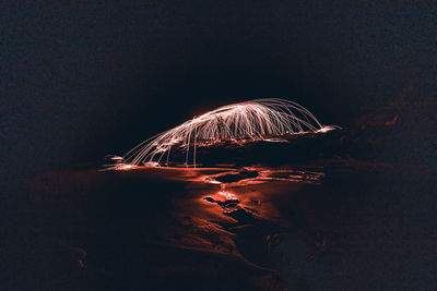 Firework display over water at night