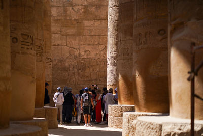Rear view of people standing by ancient structure
