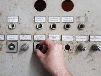 Cropped hand of man adjusting machinery knob